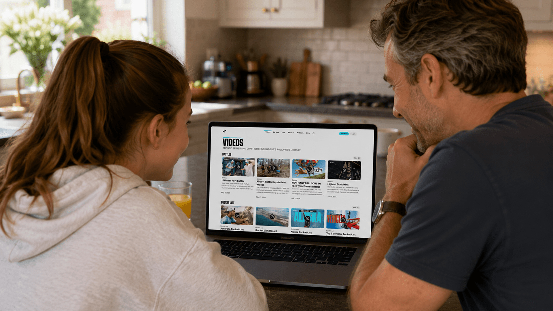 Two Dude Perfect fans browsing the platform’s video library together on a laptop at home.