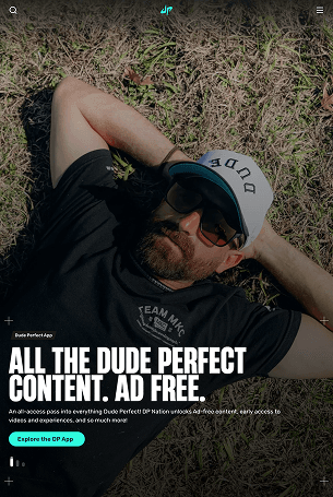 Dude Perfect mobile homepage featuring a member of the group relaxing on grass, with a headline promoting ad-free content and a link to explore the app.